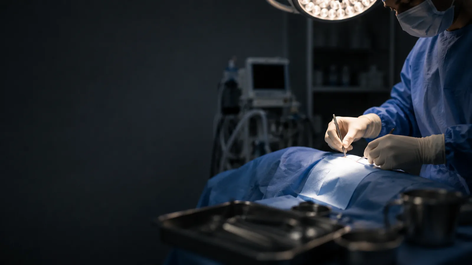 A surgeon operating under a surgical lamp